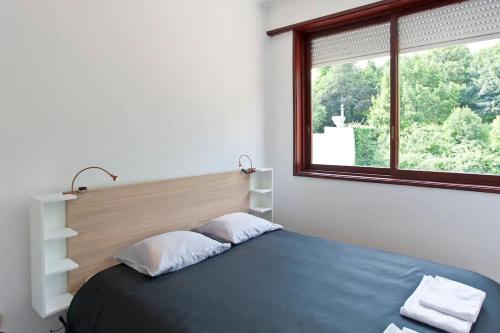 1 dormitorio con 1 cama y ventana grande en O´Porto Torrinha Flat, en Oporto