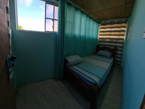 Cama pequeña en habitación con ventana en Casa Hostel San Andres, en San Andrés