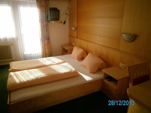 a small bedroom with a bed and a television at Gästehaus Hirschenhof in Sölden