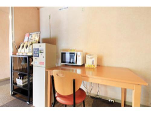 a kitchen with a table with a microwave and a refrigerator at Fuji Green Hotel - Vacation STAY 18926v in Fuji