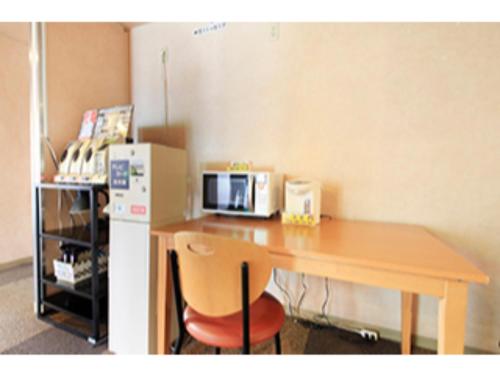 een keuken met een tafel, een magnetron en een koelkast bij Fuji Green Hotel - Vacation STAY 18931v in Fuji