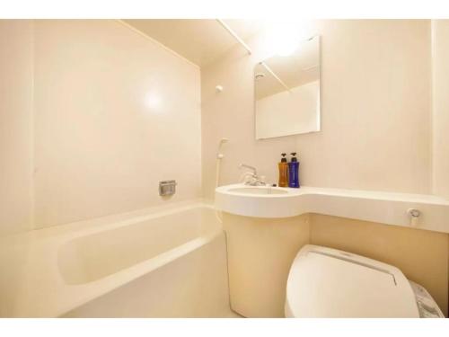 a white bathroom with a toilet and a sink at Fuji Green Hotel - Vacation STAY 18923v in Fuji