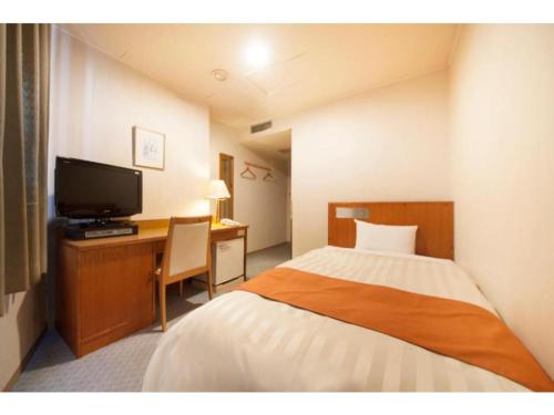 a hotel room with a bed and a desk with a television at Fuji Green Hotel - Vacation STAY 18922v in Fuji