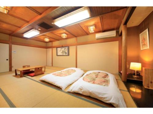 Fujinomiya Green Hotel - Vacation STAY 19035v في فوجينوميا: غرفة فيها سرير وطاولة فيها