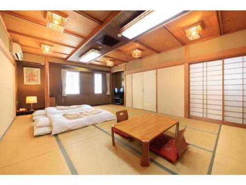 a room with a bed and a table in it at Fujinomiya Green Hotel - Vacation STAY 19035v in Fujinomiya