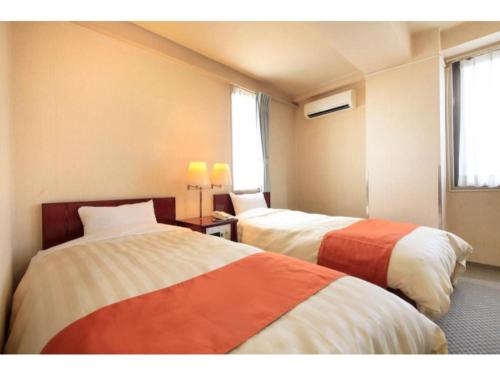 a hotel room with two beds and a window at Fujinomiya Green Hotel - Vacation STAY 19030v in Fujinomiya