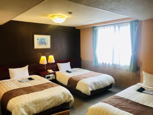 a hotel room with two beds and a window at Fujinomiya Green Hotel - Vacation STAY 19038v in Fujinomiya