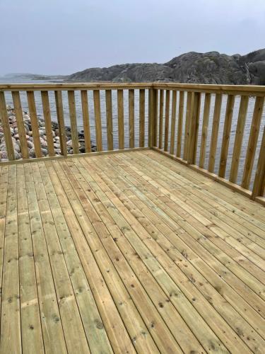 a wooden deck with a view of the ocean at Seaview Cottage Solvik - Kungshamn in Kungshamn