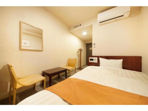 a hotel room with a bed and two chairs at Fujinomiya Green Hotel - Vacation STAY 19015v in Fujinomiya