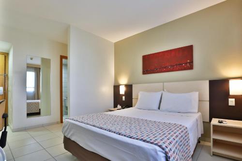 a bedroom with a large bed in a room at Comfort Hotel Goiânia in Goiânia