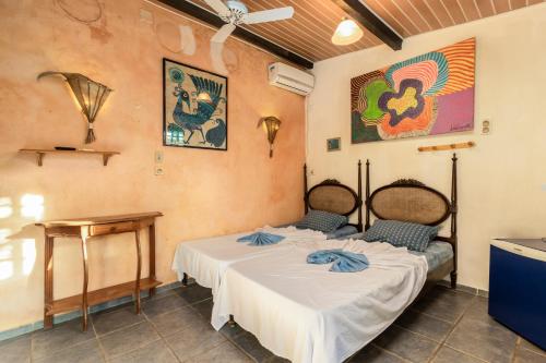 a room with two beds and a table in it at Pousada Aguas Marinhas in Cabo de Santo Agostinho