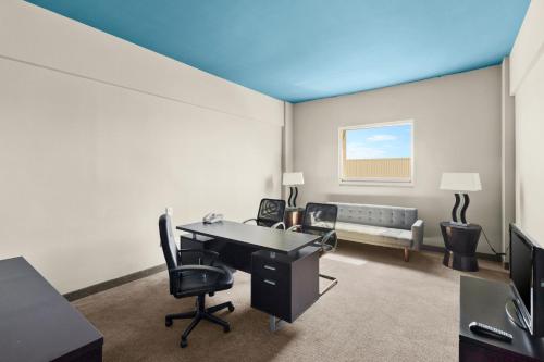 an office with a desk and chairs and a couch at Hotel Aeropuerto Los Cabos in San José del Cabo