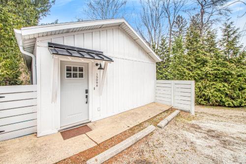 a white garage with a white door in a driveway at The Gatehouse on Orchard Beach in Lakeside