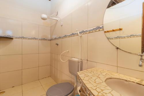 a bathroom with a toilet and a sink and a mirror at Pousada Aguas Marinhas in Cabo de Santo Agostinho