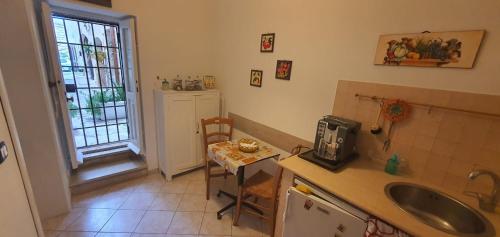 a kitchen with a sink and a table and a window at Lungomare Elio Vittorini in Siracusa