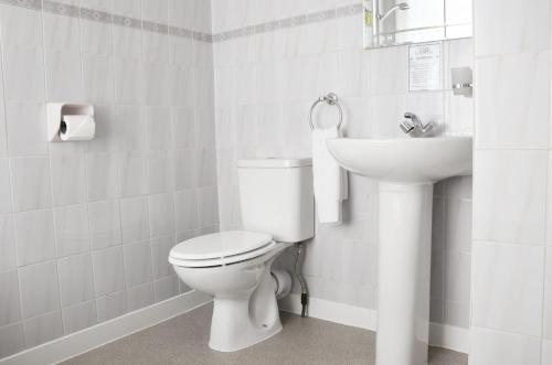 ein weißes Bad mit einem WC und einem Waschbecken in der Unterkunft The Gurkha Hotel in Blackpool