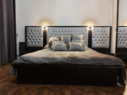 a bedroom with a large bed with two lights on it at In the heart of the city in Kharkiv