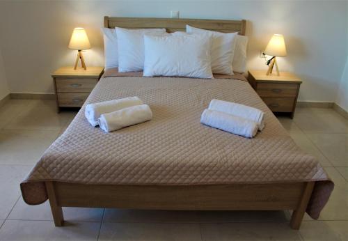 a bedroom with a large bed with two pillows on it at Blue Sand Apartment in Analipsi