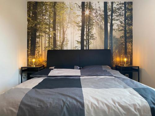 1 dormitorio con 1 cama con un mural de bosque en la pared en Casa Wimmer, en Allendorf an der Lumda