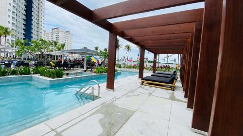 uma piscina com uma chaise longue ao lado de um edifício em Salinas Exclusive Resort em Salinópolis