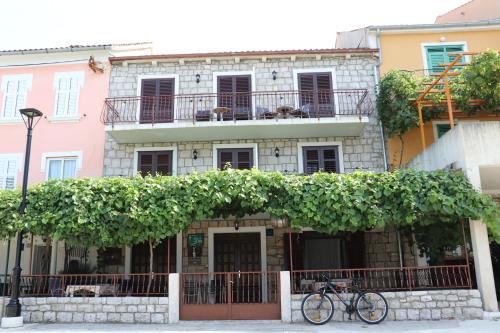 a bike parked in front of a building with vines at APARTMANI JURIĆ in Trpanj