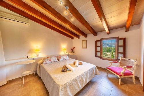 een slaapkamer met een bed, een tafel en een stoel bij Villa Mala Garbo in Pollença