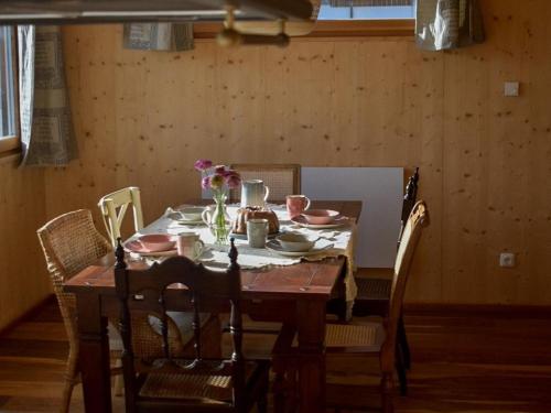 a dining room table with chairs and a table with flowers on it at Ferienhaus mit Charme in Attersee am Attersee