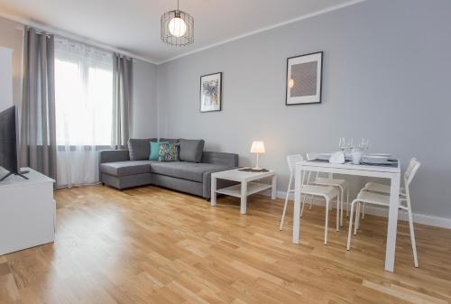 - un salon avec un canapé et une table dans l'établissement CR Apartament Centrum Zamenhofa 1, à Białystok