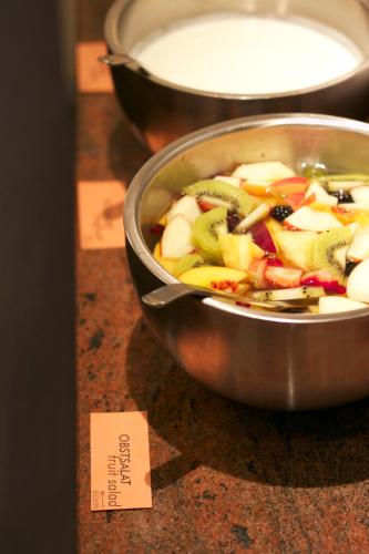 a bowl of vegetables on a table with a note at Hotel & Apartments Böhm in Gravenwerth