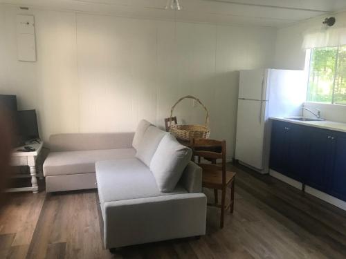 a living room with a couch and a kitchen at Beachside on Lake Muskoka in Port Carling