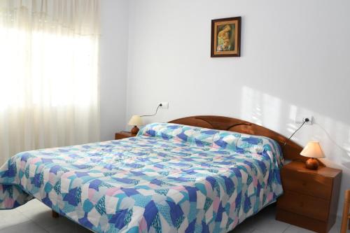 1 dormitorio con 1 cama con edredón azul y blanco en Casa Teresita, en Deltebre