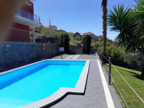 a swimming pool in front of a house at Quinta do Brasil in Arco da Calheta