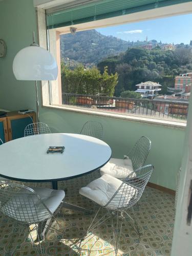 a table and chairs in a room with a large window at Grande Attico con Vista Vicino al Centro by PortofinoVacanze in Rapallo