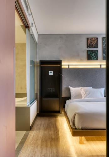a bedroom with a large bed and a large window at Novotel BH Savassi in Belo Horizonte