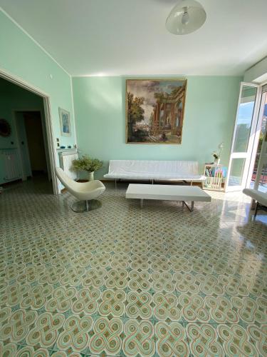 a living room with a white couch and a table at Grande Attico con Vista Vicino al Centro by PortofinoVacanze in Rapallo