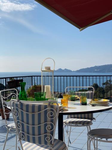 a table on a balcony with a view of the ocean at Grande Attico con Vista Vicino al Centro by PortofinoVacanze in Rapallo