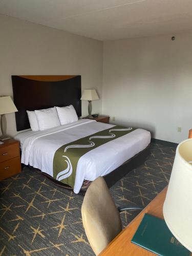 スプリング・バレーにあるQuality Inn Spring Valley - Nanuetの大きなベッドとデスクが備わるホテルルームです。