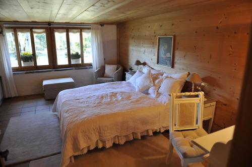 ein Schlafzimmer mit einem großen Bett in einem Holzzimmer in der Unterkunft Chalet Nyati in Gstaad