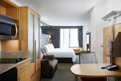 una camera d'albergo con letto e tavolo di The Jewel Hotel, New York a New York