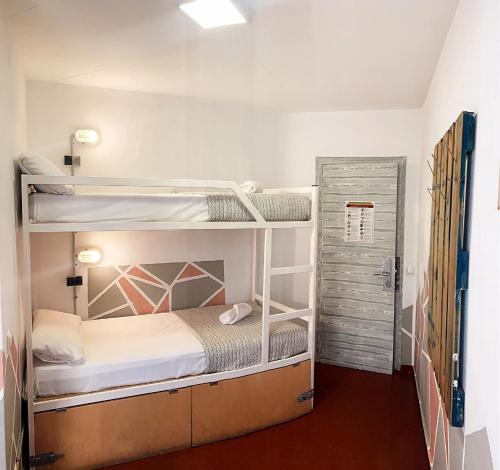 リョレート・デ・マルにあるApartments centro Lloret para 6の二段ベッド2台とドアが備わる客室です。