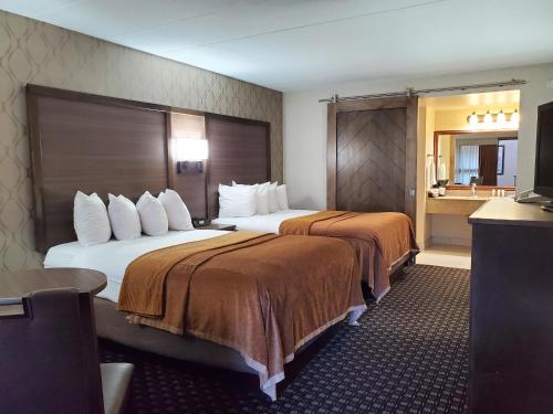 ウォータータウンにあるRamkota Hotel Watertownのベッド2台とバスルームが備わるホテルルームです。
