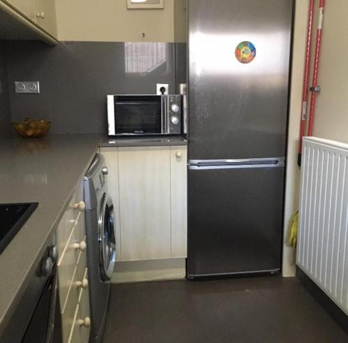 une cuisine avec un réfrigérateur et un micro-ondes dans l'établissement Les Isards, à Bourg-Madame