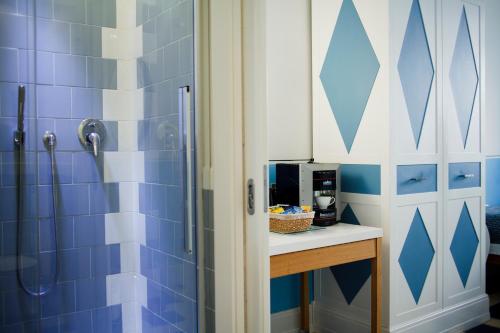 a bathroom with a blue and white tiled wall at Piazza Di Spagna Prestige in Rome