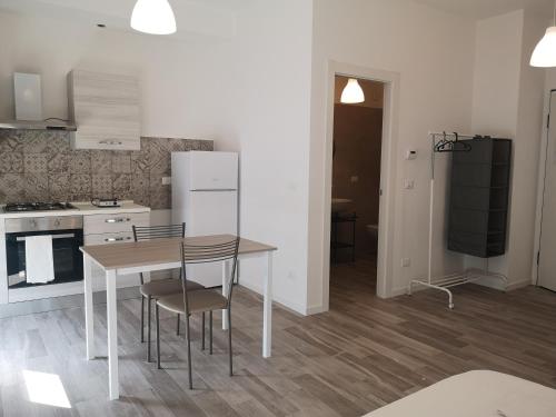 a kitchen with a table and chairs in a room at Battistelli Apartments in Bologna