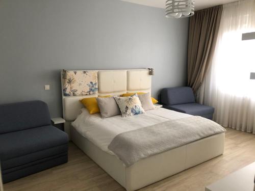 - une chambre avec un lit et deux chaises bleues dans l'établissement Apartment Life Osijek, à Osijek