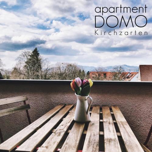 a vase of flowers sitting on a wooden bench at Apartment DOMO Kirchzarten in Kirchzarten