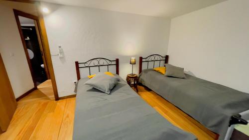 a bedroom with two beds and a hallway at Casa do Avô in Sistelo