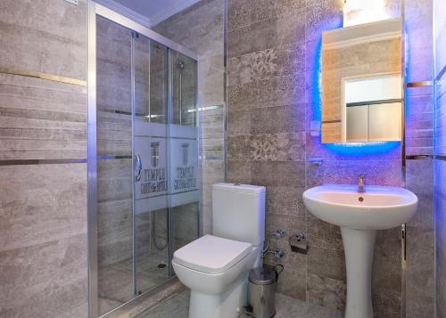 a bathroom with a toilet and a sink and a shower at Temple Hotel in Didim