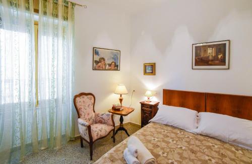 a bedroom with a bed and a chair and a window at Casa Marta IUN Q1985 in Nuoro