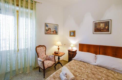 1 dormitorio con 1 cama, 1 silla y 1 ventana en Casa Marta IUN Q1985, en Nuoro